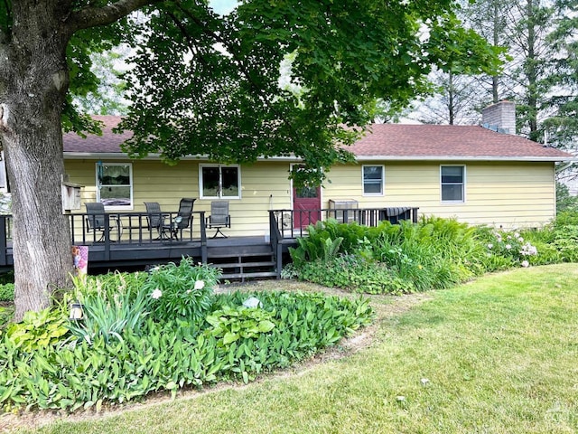 back of house featuring a lawn and a wooden deck