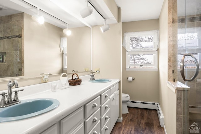 bathroom with baseboard heating, an enclosed shower, toilet, vanity, and hardwood / wood-style flooring