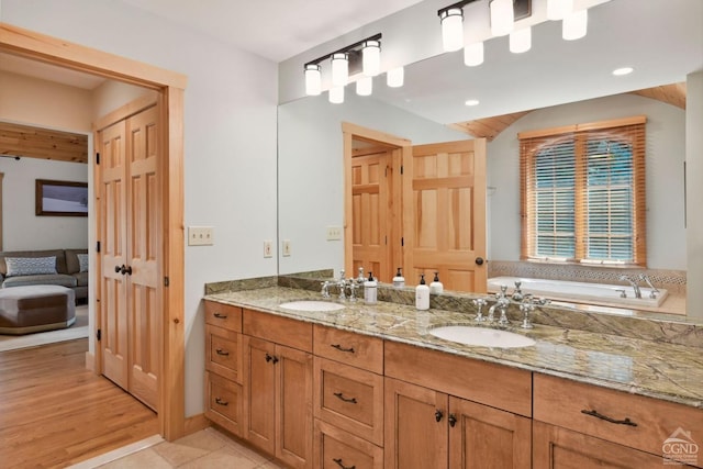 bathroom featuring wood-type flooring, vanity, and a tub to relax in