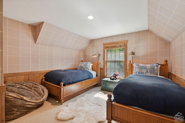 carpeted bedroom featuring lofted ceiling and tile walls