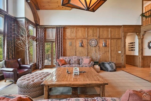 living room featuring hardwood / wood-style flooring, high vaulted ceiling, wooden walls, and wood ceiling