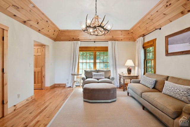 living room with light wood-type flooring, an inviting chandelier, and a healthy amount of sunlight