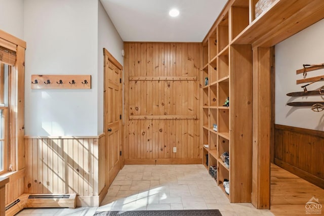 mudroom featuring wood walls, a baseboard radiator, and light hardwood / wood-style flooring