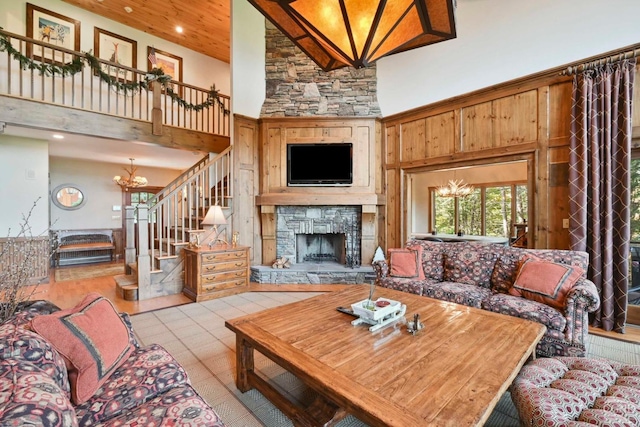 living room featuring light tile patterned floors, a fireplace, high vaulted ceiling, and an inviting chandelier