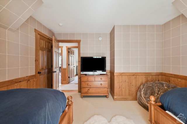 carpeted bedroom featuring wooden walls and tile walls