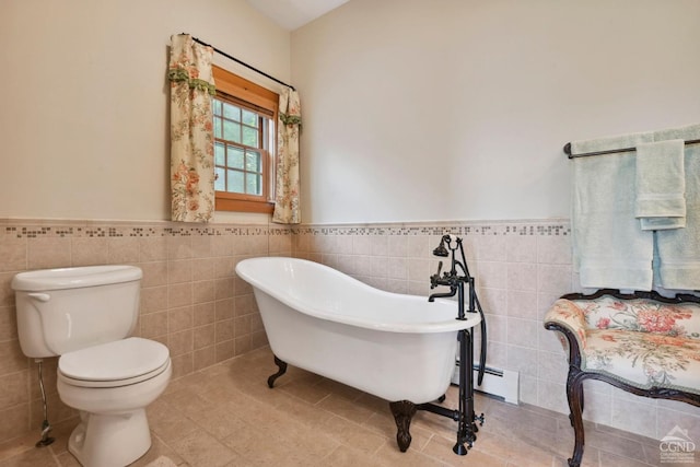 bathroom featuring baseboard heating, tile walls, and a tub