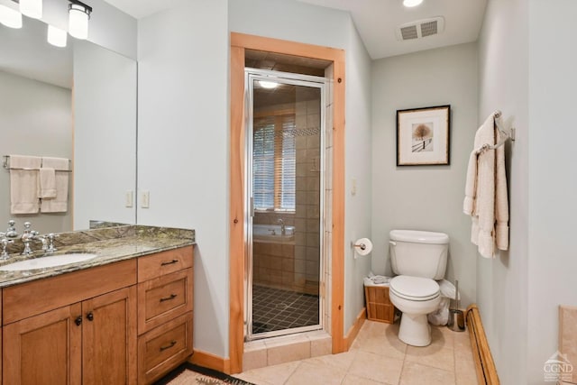 bathroom with tile patterned floors, vanity, toilet, and a shower with door