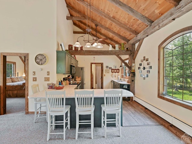 kitchen featuring a breakfast bar, wood ceiling, green cabinets, pendant lighting, and a baseboard heating unit