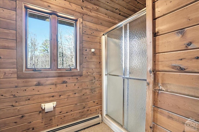 bathroom with wooden walls, a shower stall, and a baseboard radiator