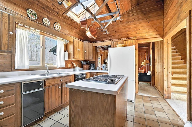 kitchen with stovetop with downdraft, a sink, light tile patterned floors, and light countertops