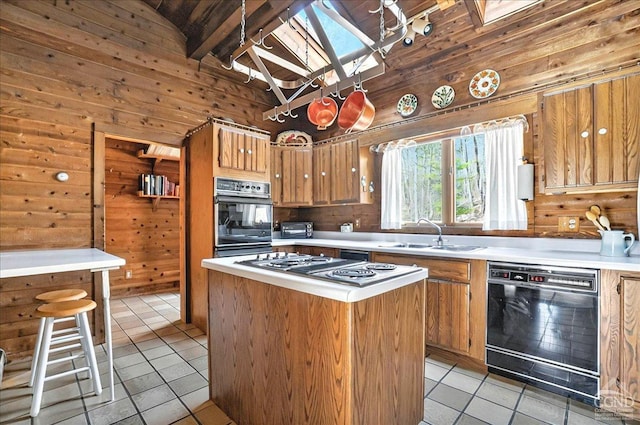 kitchen featuring wood walls, a sink, and black appliances