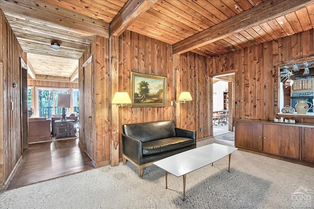 sitting room featuring carpet floors, wood walls, wood ceiling, and beam ceiling