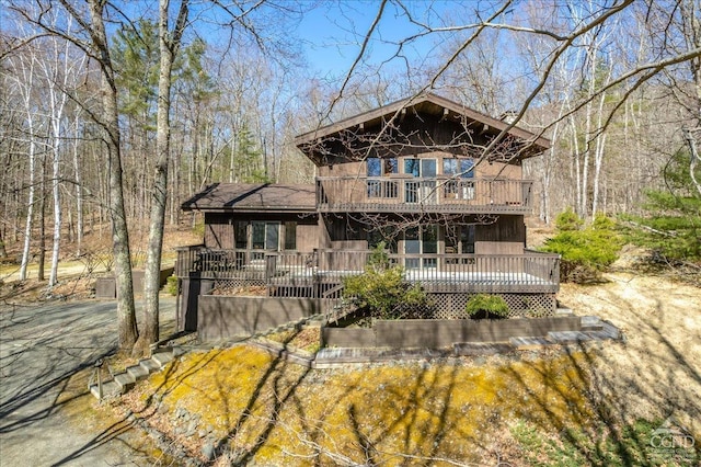back of property featuring a wooden deck and a balcony