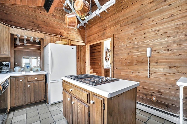 kitchen featuring wooden walls, light tile patterned flooring, freestanding refrigerator, a baseboard radiator, and stainless steel electric stovetop