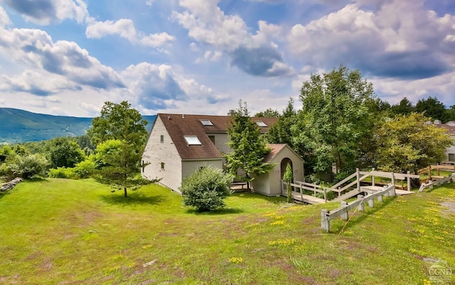 view of property exterior with a lawn and a mountain view