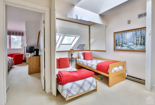 bedroom with a skylight, carpet floors, and a baseboard heating unit