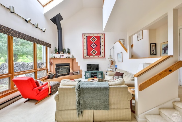 living room with carpet flooring, a skylight, high vaulted ceiling, and a baseboard radiator