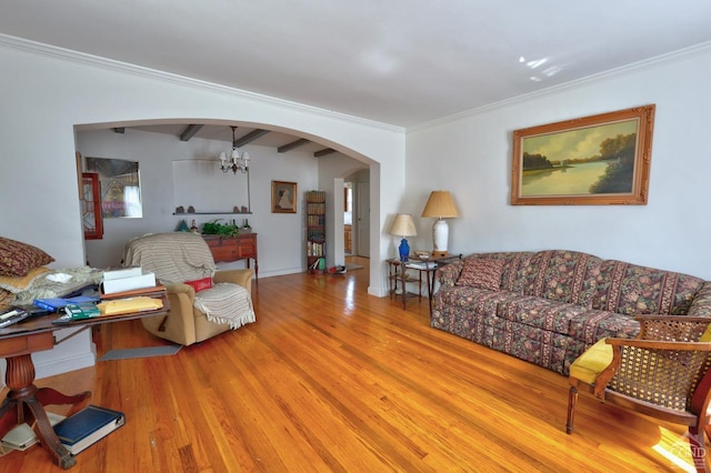 living room featuring arched walkways, wood finished floors, and ornamental molding