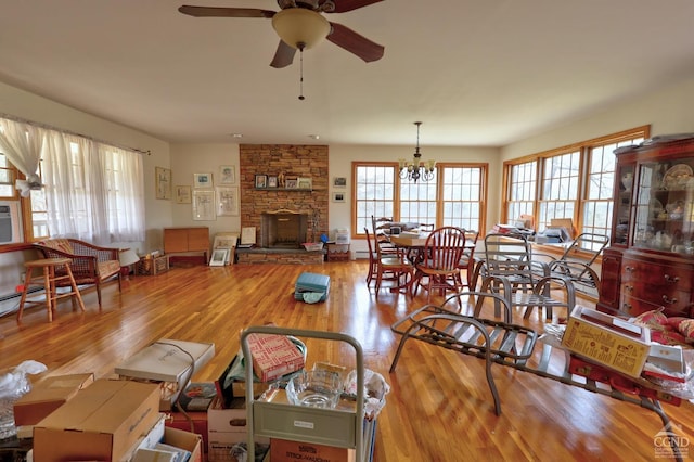 living room featuring a fireplace, a ceiling fan, and wood finished floors