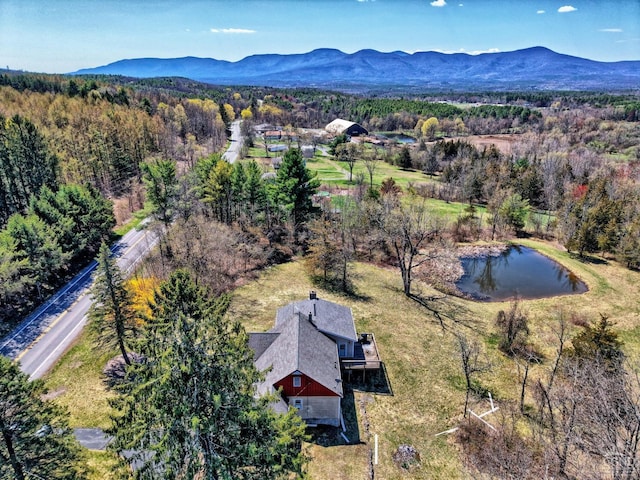 drone / aerial view with a view of trees and a water and mountain view