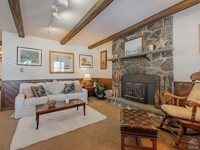 carpeted living area with beam ceiling, rail lighting, and a wainscoted wall