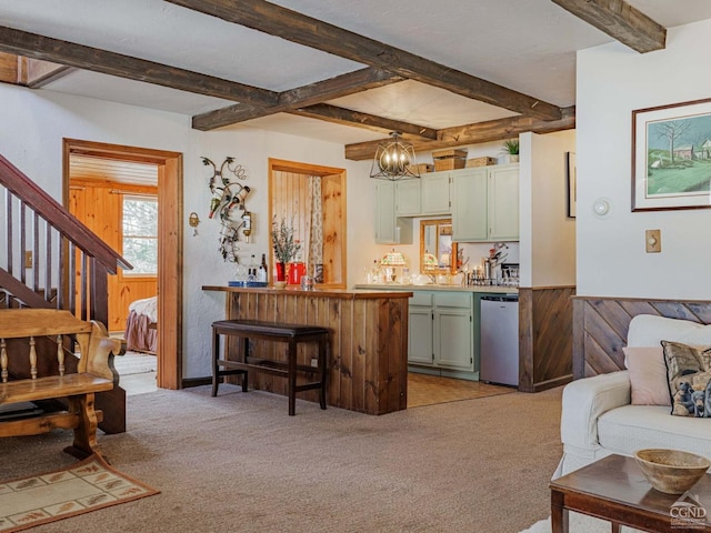 kitchen with stainless steel dishwasher, beamed ceiling, green cabinets, light colored carpet, and a breakfast bar