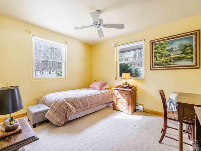 bedroom featuring light carpet, a baseboard radiator, baseboards, and a ceiling fan