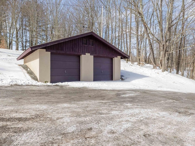 snow covered garage featuring a garage