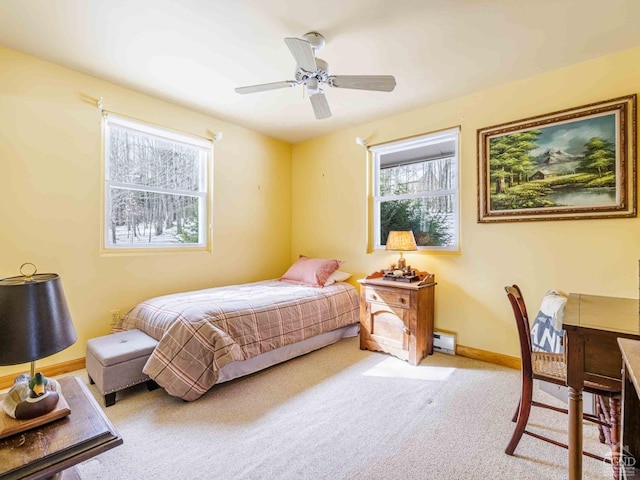 bedroom with a baseboard radiator, ceiling fan, multiple windows, and carpet floors
