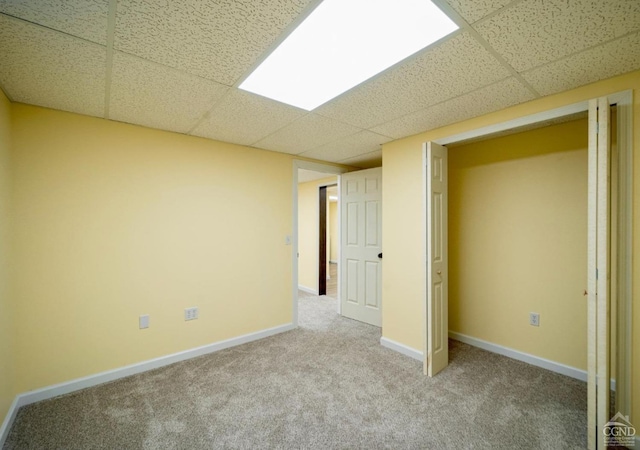 unfurnished bedroom featuring a paneled ceiling and carpet