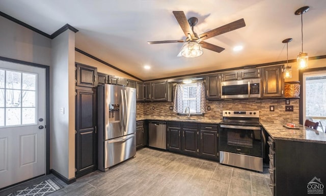 kitchen with light stone counters, stainless steel appliances, vaulted ceiling, ceiling fan, and pendant lighting