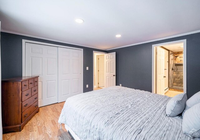 bedroom with light hardwood / wood-style flooring, a baseboard heating unit, ensuite bathroom, crown molding, and a closet