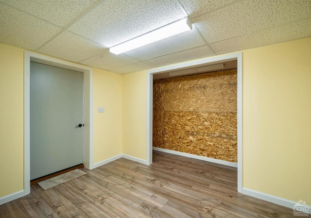 empty room featuring a paneled ceiling and light wood-type flooring