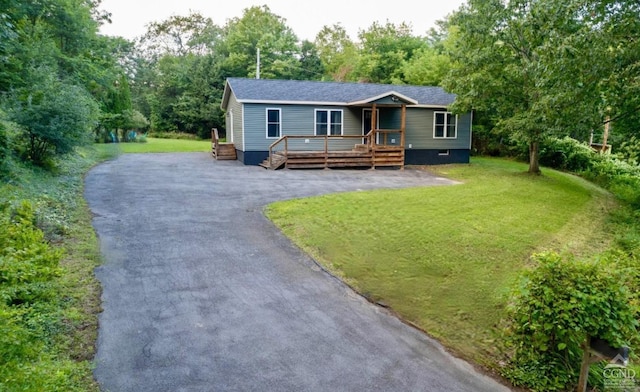 view of front of property featuring a wooden deck and a front lawn