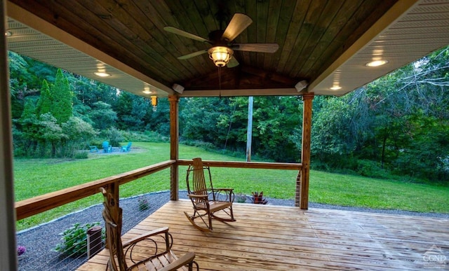 wooden deck featuring ceiling fan and a yard