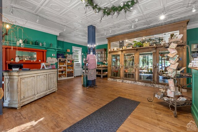 interior space with radiator, crown molding, french doors, and hardwood / wood-style flooring