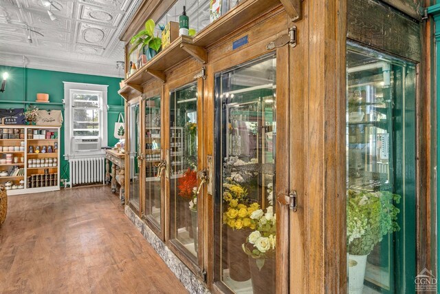 doorway with radiator heating unit, cooling unit, and hardwood / wood-style floors