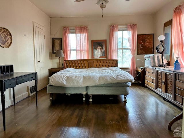 bedroom featuring ceiling fan, dark hardwood / wood-style flooring, and multiple windows