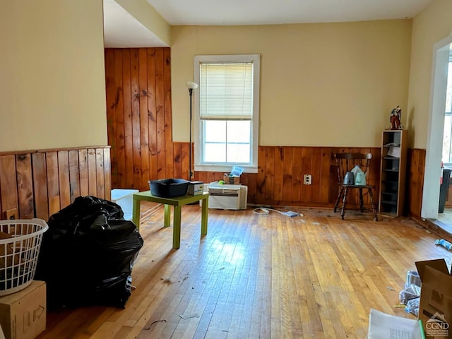 living area with wooden walls and light hardwood / wood-style flooring