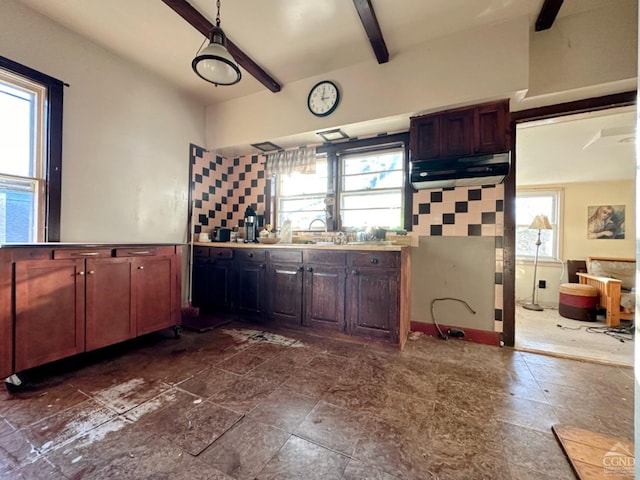 kitchen with backsplash, beamed ceiling, and a healthy amount of sunlight