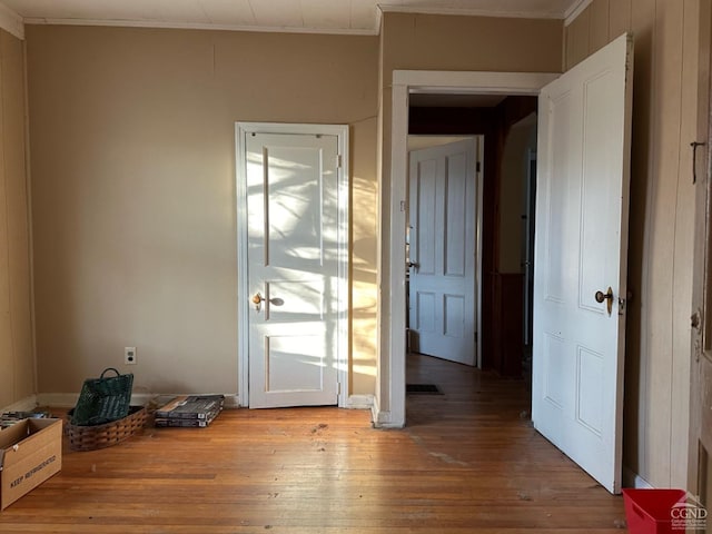 doorway featuring wood-type flooring and crown molding