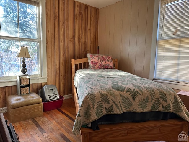 bedroom with wooden walls and hardwood / wood-style floors