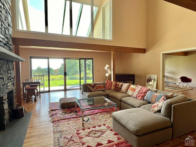 living room with a fireplace, a high ceiling, and light hardwood / wood-style flooring