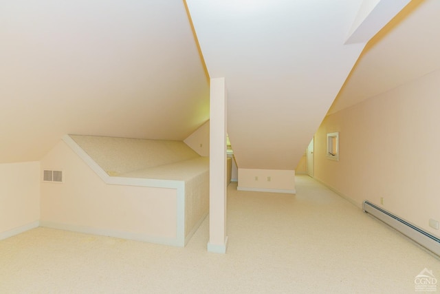 additional living space featuring light colored carpet, vaulted ceiling, and a baseboard heating unit