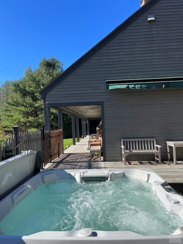 view of swimming pool featuring a hot tub and a deck