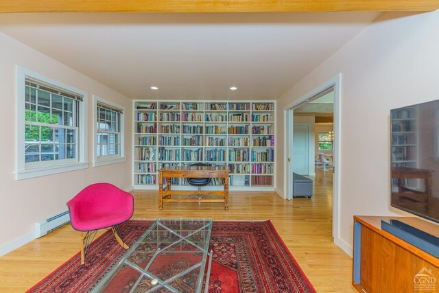 living area featuring baseboard heating and hardwood / wood-style floors