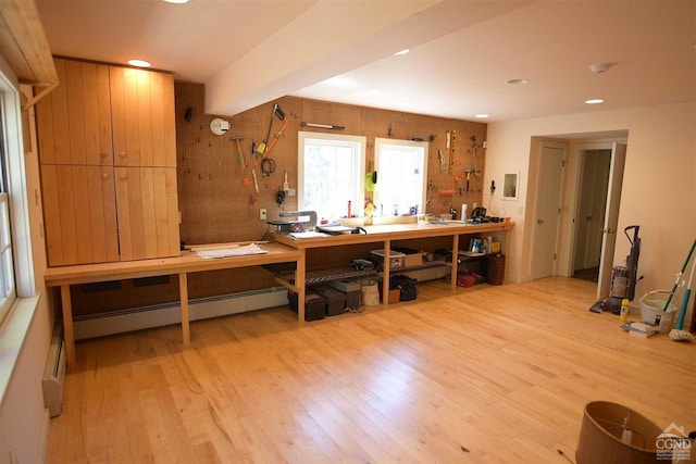 miscellaneous room with a workshop area, light hardwood / wood-style floors, and a baseboard radiator