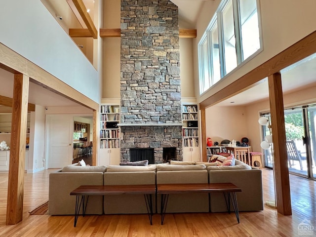 living room featuring a fireplace, a high ceiling, and light wood-type flooring