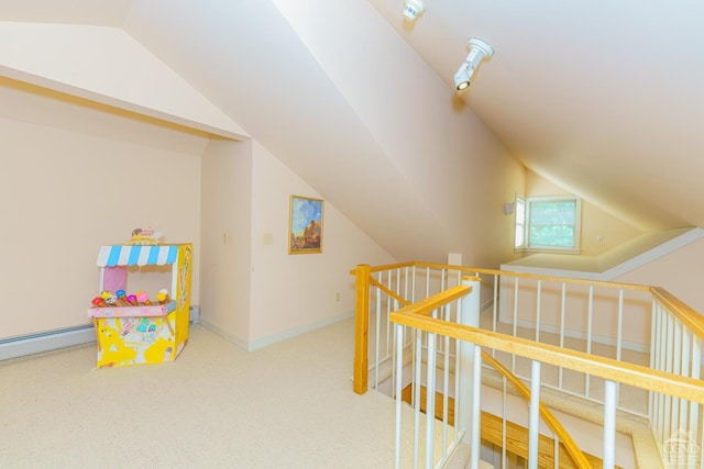 playroom with carpet floors, a baseboard radiator, and vaulted ceiling