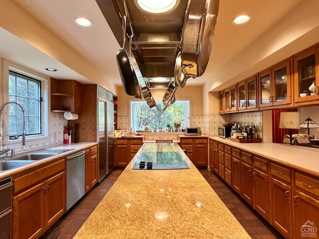 kitchen with decorative backsplash, sink, light stone countertops, and stainless steel appliances